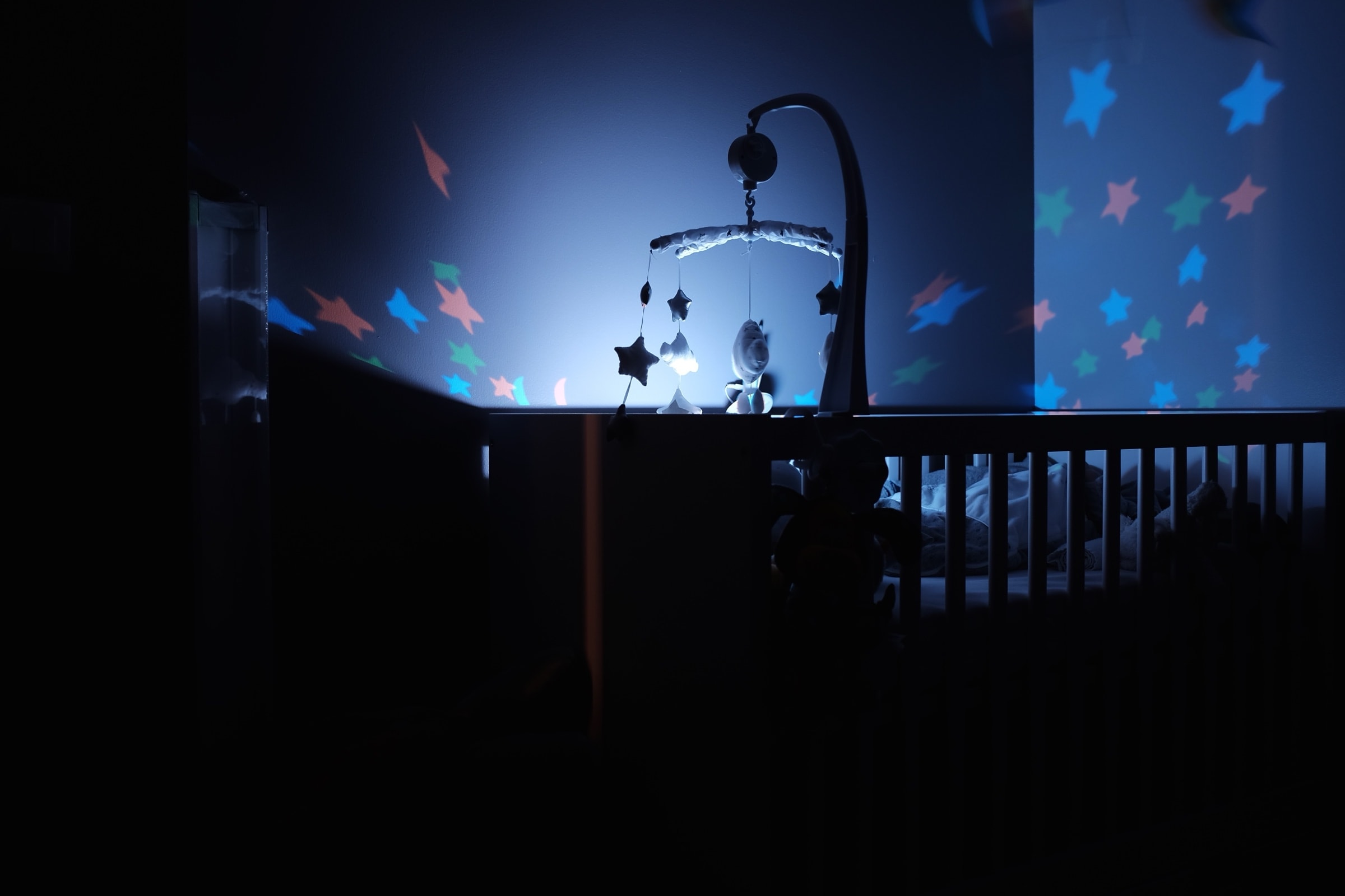 Empty crib in a dimly lit nursery at night