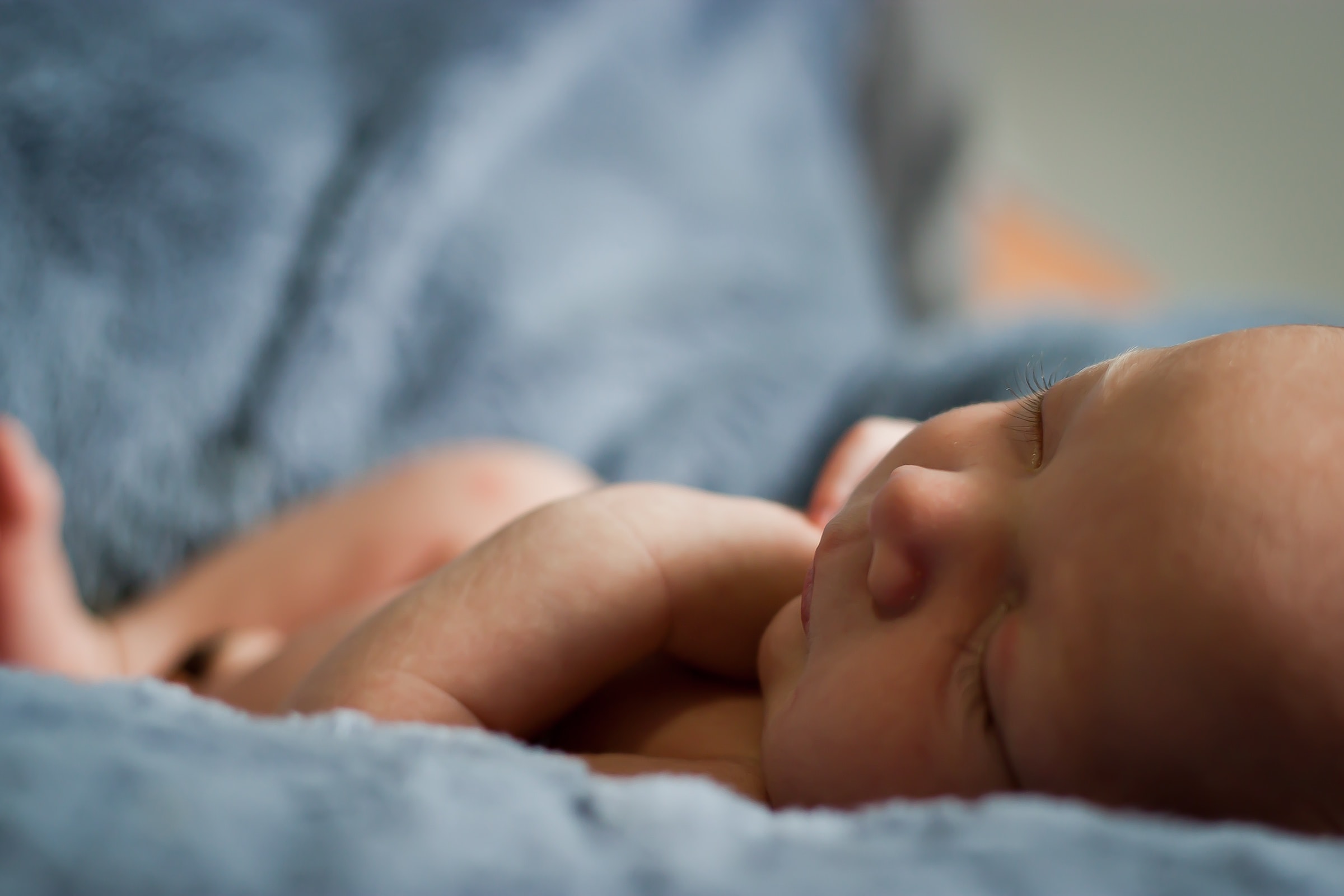 A baby asleep under a soft blanket